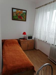 Dormitorio pequeño con cama y microondas en Centrum One en Suwałki