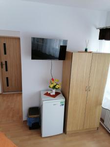 a room with a refrigerator and a tv on a wall at Centrum One in Suwałki