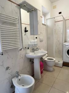 een witte badkamer met een wastafel en een toilet bij Appartamento estivo seconda fila dal mare in Grottammare
