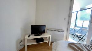 - une chambre avec une télévision sur une table et un lit dans l'établissement Studio Grenoble Universités-Saint Martin D'hères, à Saint-Martin-dʼHères