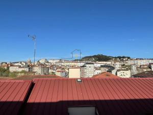uma vista para uma cidade com um telhado vermelho em O cuarto de abastos em Ourense
