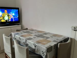 uma mesa com uma toalha de mesa com uma televisão em Appartamento estivo seconda fila dal mare em Grottammare