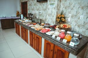 a buffet of food on a counter in a kitchen at Frota Palace Hotel in Macapá