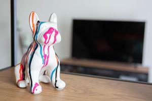a toy dog figurine sitting on a table in front of a television at TITI's House Townhouse & holiday home in Grandcamp-Maisy