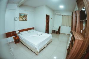 Schlafzimmer mit einem Bett und einem Flachbild-TV in der Unterkunft Frota Palace Hotel in Macapá