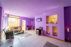 sala de estar con paredes de color púrpura y sofá en Hotel Aqua Thermal Spa en Baile Felix