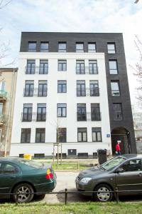 two cars parked in front of a building at Nowy Apartment przy Placu Szembeka in Warsaw