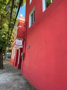 un edificio rojo con un cartel en el costado en Reef Hostel & Pousada en Recife