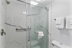 baño con ducha y puerta de cristal en Studio 6 Wilmington, NC en Wilmington