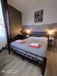 a bedroom with a large bed with two towels on it at Hotel Le Bon Moine in Reims