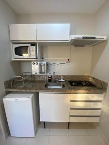 カルダス・ノバスにあるPrive Boulevard Suite Hotelのシンクと電子レンジ付きの小さなキッチン