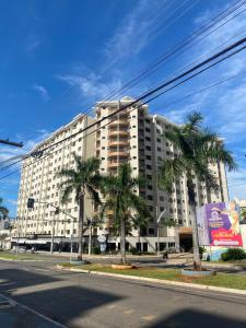 カルダス・ノバスにあるPrive Boulevard Suite Hotelのヤシの木が前に立つ大きな白い建物