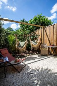 a patio with two hammocks and a fence at O'Jane de Boy in Lège-Cap-Ferret