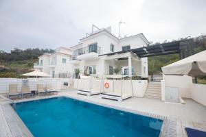 a villa with a swimming pool and a house at Romeo & Juliet in Protaras