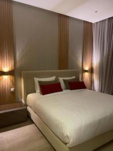 a bedroom with a large bed with two red pillows at Anfa Place, Luxury Apartment just renovated, Ocean View in Casablanca