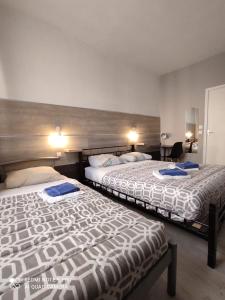 dwa łóżka w pokoju hotelowym z dwoma łóżkami w obiekcie Le Bon Moine w mieście Reims