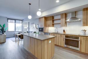 a large kitchen with wooden cabinets and a kitchen island at Gorgeous 1 Bedroom At Clarendon With Gym and Rooftop in Arlington