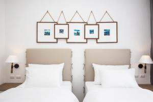 2 Betten in einem Schlafzimmer mit 3 Bildern an der Wand in der Unterkunft Marina Express-Fisherman Aonang in Ao Nang Beach