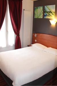 a hotel room with a bed and a television at Kyriad Hotel XIII Italie Gobelins in Paris