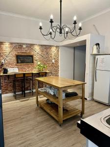 uma cozinha com uma mesa de madeira e uma parede de tijolos em Hotel Hey U em Santa Fé