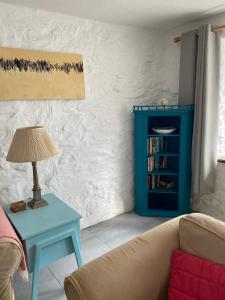 uma sala de estar com um sofá e uma mesa azul em Bodriggy Barn Holiday Cottage near St Ives em Hayle