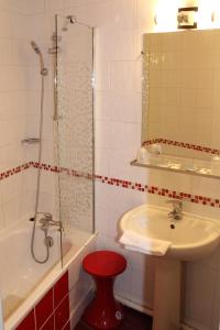 a bathroom with a tub and a sink and a shower at Kyriad Hotel XIII Italie Gobelins in Paris