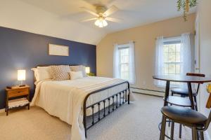 a bedroom with a bed and a table and two windows at Sauna, Spa and Stargazing Coudersport Home! in Coudersport