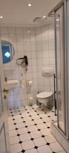 a bathroom with a toilet and a tv on the wall at Ferienwohnung Baltrum auf dem Elisenhof Hagermarsch in Hagermarsch +31 photos