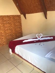 Un dormitorio con una cama con una decoración de corazón. en Pousada Vereda das Aguas en Ponte Alta do Tocantins
