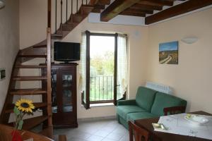 a living room with a green couch and a staircase at Casa Vacanze San Francesco in Bagni San Filippo