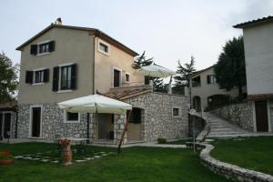 una casa con un paraguas en el patio en Casa Vacanze San Francesco en Bagni San Filippo