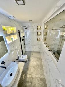 a white bathroom with a sink and a toilet at Il Rifugio in Marettimo