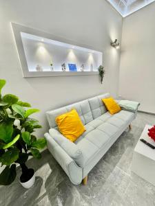 a white living room with a couch with yellow pillows at Il Rifugio in Marettimo