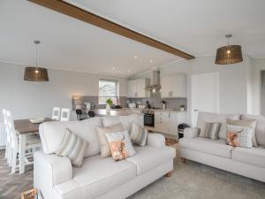 a living room with two white couches and a kitchen at Penmarlam Lodge Retreat 5 in Fowey