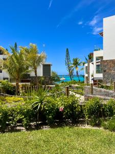 a view of a resort with palm trees and the ocean at Exclusive beachfront apartment in Belle Mare