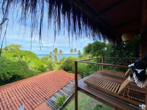 a porch of a house with a view of the ocean at Saudade da Bahia in Moreré