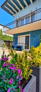 a garden with flowers in front of a house at Appartamenti Scilla e Lavinia in Riva del Garda