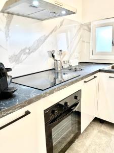 uma cozinha com armários brancos e um forno de fogão preto em Il Rifugio em Marettimo