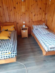 2 Betten in einem Holzzimmer mit einem Tisch in der Unterkunft La poalele Raraului!!! in Câmpulung Moldovenesc + 63 Fotos