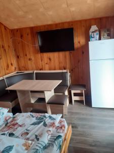 ein Esszimmer mit Tisch und Kühlschrank in der Unterkunft La poalele Raraului!!! in Câmpulung Moldovenesc