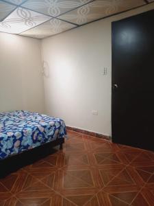 1 dormitorio con 1 cama y puerta en una habitación en Habitaciones Isa; lugar para tu descanso, en Armenia