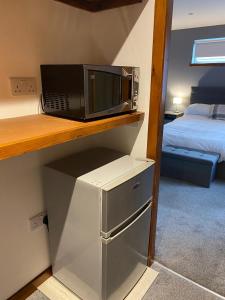a microwave on a shelf in a room with a bed at Number 6 in Fort William