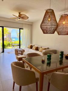 a living room with a couch and a table and chairs at Exclusive beachfront apartment in Belle Mare