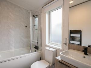 y baño con aseo, lavabo y ducha. en Penmarlam Lodge Retreat 18 en Fowey