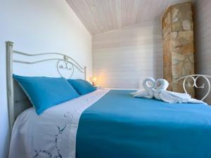 Villa Barnaba Country House & Pool في بولينيانو آ ماري: غرفة نوم بسرير ازرق وفوط بيضاء