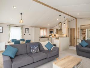 a living room with a couch and a kitchen at Penmarlam Lodge Retreat 12 in Fowey