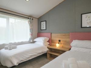 a bedroom with two beds and a window at Penmarlam Lodge Retreat 12 in Fowey