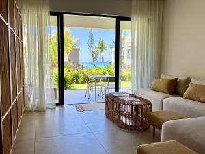 a living room with a couch and a table at Exclusive beachfront apartment in Belle Mare
