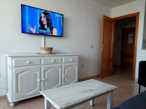 a tv on a wall above a white dresser at Best View - Welcome Penthouse Apartamentos Karola in Benidorm
