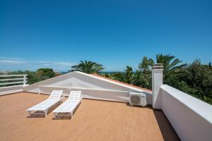 twee witte stoelen op het dak van een huis bij Villa Barnaba Country House & Pool in Polignano a Mare